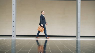 İş adamlarının bavul tutarken ve şehir merkezindeki iş yerine yürürken yan görüntüsü. Profesyonel proje yöneticisi dışarıda resmi takım elbise giyerken toplantıya gidiyor. Urbane.