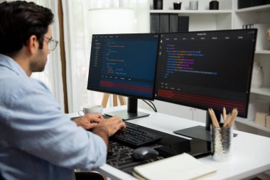 Akıllı IT geliştiricisi yazılım geliştirme kodlaması ile modern ofisteki iki bilgisayar kodlu bilgisayar sistemi üzerinde uygulama programı güncelleme çevrimiçi web sitesi yaratıyor. Tahmin et..