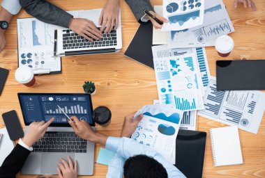 Çok ırklı analist ekibi toplantıdaki finansal verileri analiz etmek için BI Fintech yazılımı kullanıyor. Üst görünüm finans paneli veri ekranında pazarlama göstergesi için analiz edilmiş grafikle birlikte. Uyum