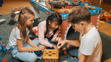 Anaokulunun oyun odasında ahşap blok oynayan çok kültürlü ve zeki öğrencilerin en iyi görüntüsü. Çeşitli çocuklar yaratıcılığı ve hayali geliştirmek için oyuncak oynarlar. Yaratıcı aktivite konsepti. Etkinlik.