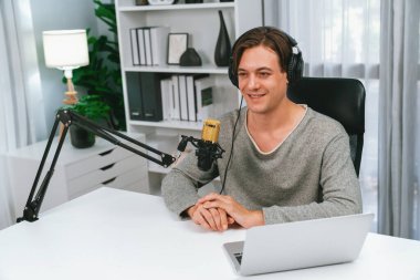 Sunucu kanalı, gülümseyen akıllı yayıncı kaydı, senaryosu ve akıllı telefonuyla sosyal medyada sohbet programı, kulaklık takarak modern ev stüdyosundaki video flamalarını kaydediyor. Bireysel.