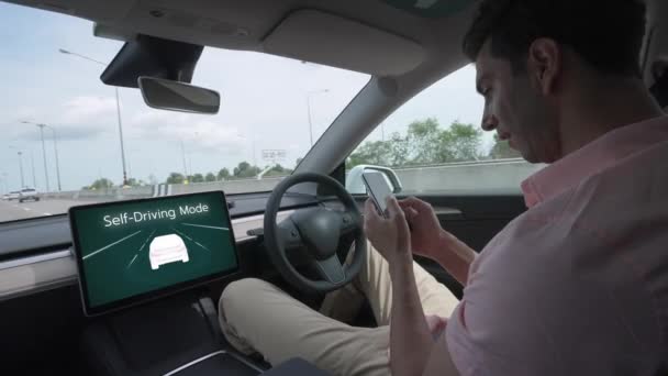 自动驾驶汽车或自动驾驶汽车在无驱动系统和自动驾驶模式的高速高速公路上行驶 使司机可以放松下来 在不危害安全的情况下专注于智能手机 太奇怪了 — 图库视频影像