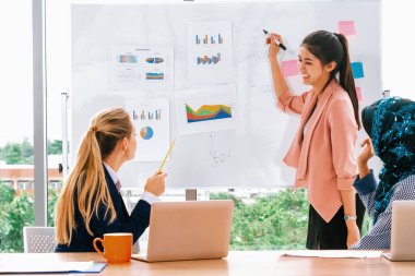 Çok kültürlü çalışma grubu. Farklı etnik kökenden iş kadınları, Kafkasyalı, Asyalı ve Araplardan oluşan bir ekip ofiste dizüstü bilgisayarla birlikte çalışıyor. Çok ırklı takım çalışması konsepti. uds