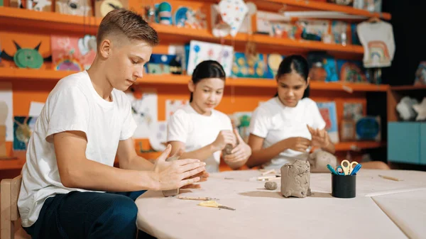 白种人聪明的少年在艺术课上渴望一杯黏土的同时 也在模仿黏土 一群多文化快乐的学生在陶瓷作坊里做面团工作 创造性活动概念 — 图库照片