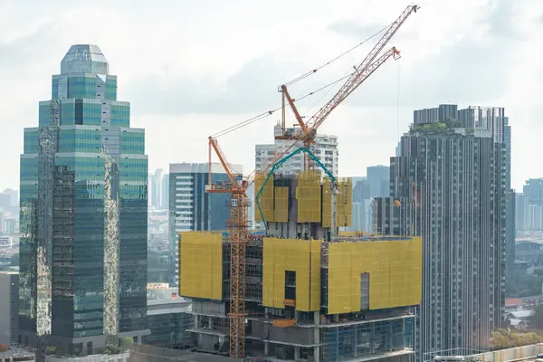 塔式起重机的外立面摩天大楼的图像 城市景观正在建设中 起重机在工作 以翻修建筑物 蓝天背景建筑学 装饰过的 — 图库照片