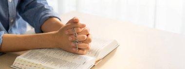 Asyalı erkek, kutsal İncil 'in üzerinde el pençe divan dururken dua etti. Ruhani, dini, inancı, ibadeti, Hıristiyanlığı ve Tanrı 'nın kutsamasını. Geçmişi bulanıklaştırıyor. Filizlenen.