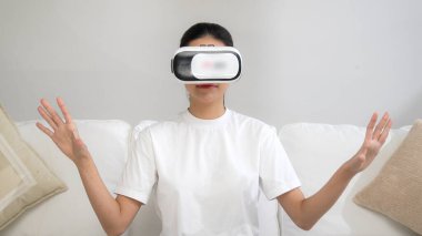 Canlı online alışveriş deneyimi için sanal gerçeklik gözlüğü kullanan genç bir kadın. Sanal gerçeklik VR yeniliği kadın dijital eğlence yaşam tarzı için optimize edildi.