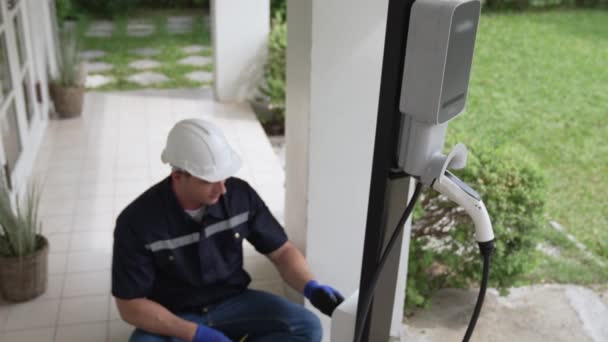 Wykwalifikowany Technik Instaluje Domową Stację Ładowania Pojazdów Elektrycznych Świadcząc Usługi — Wideo stockowe