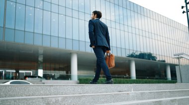 Ofise giderken merdivenlerden çıkan başarılı bir iş adamı bacağı. Proje yöneticisi iş yerini değiştiriyor, yeni bir şey keşfediyor, gelişiyor, terfi ediyor ya da gün ışığına çıkıyor. Ayağa kalkın. Sevinçli..