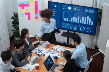 Genç Afrikalı iş kadını modern toplantıda TV ekranında veri analizi paneli sunuyor. Bir grup iş adamıyla konferans odasında iş sunumu. Uyum