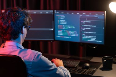 Uygulama pc ekranları ile çevrili çevrimiçi yazılım geliştirme bilgilerini yoğunlaştıran IT geliştiricisi, neon modern ofis evindeki web sitesinde yazılım için program yaratıyor. Toplayıcı.