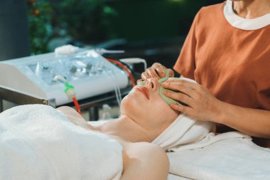 Çekici beyaz kadın elektriksel yüz bakımı görüyor. Tıp merkezindeki profesyonel doktordan tıbbi tedavi görürken güzel bir kız spa yatağında yatıyor. Huzur.