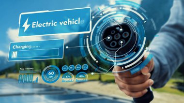 Kamera önündeki EV şarj aletine odaklan. Çevre dostu, bulanık, doğal arka planı olan bir hologram. Alternatif temiz enerji kullanarak CO2 emisyonunu azaltan EV araba şarj prizi.