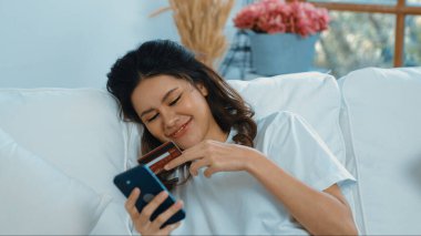 Kadın alışverişi ya da internet pazarında online ödeme modern yaşam tarzı için satılık eşyalar arıyor ve canlı siber güvenlik yazılımı tarafından korunan cüzdandan çevrimiçi ödeme için kredi kartı kullanıyor