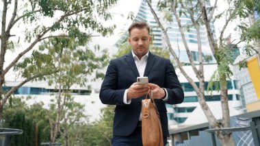 Düşük açılı kamera görüntüsü iş adamının telefonuna bakarken pazarlama ekibini arayıp Green City 'deki finansal plan hakkında fikir alışverişinde bulunması. Yönetici, iş arkadaşıyla telefonla konuşuyor. Urbane.