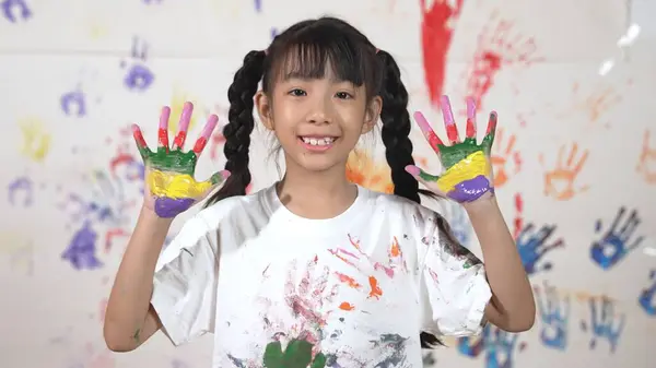 亚洲快乐的学生把双手放在一起 显示出色彩斑斓的手 微笑的女孩站在白色的背景前面 双手沾满污迹 同时看着相机 创造性活动概念 Erudition — 图库照片