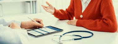 Klinikteki ya da hastane ofisindeki doktor randevusuna katılan hasta, tıbbi tedavi seçeneklerini tartışıyor ve muayene sonuçlarını ya da hastalıkla ilgili tıbbi kayıtları açıklıyor. Panorama Katı