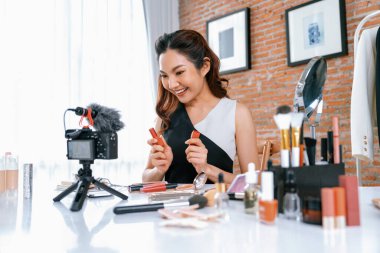 Kadın Etkilenen Vlog video görüntülerini canlı olarak çekiyor. Makyajın çoğu sosyal medya ya da blog 'u anlatıyor. Kozmetik stüdyosu ışıklandırmalı mutlu genç kız çevrimiçi pazarlama oturumu yayını için..