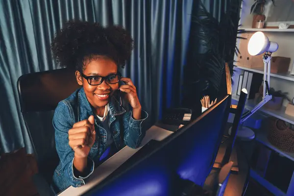 Young African American businesswoman wearing with jeans shirt concentrating on project job on monitor screen laptop, wearing jeans shirt. Concept of investment currency or asset blogger. Tastemaker.