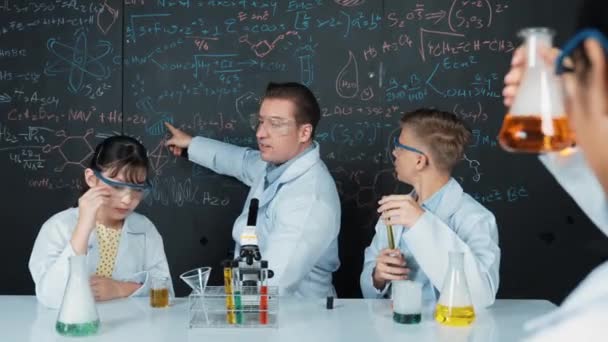 Inteligentny Nauczyciel Wyjaśnia Teorię Chemiczną Podczas Mieszania Kolorowych Rozwiązań Lub — Wideo stockowe