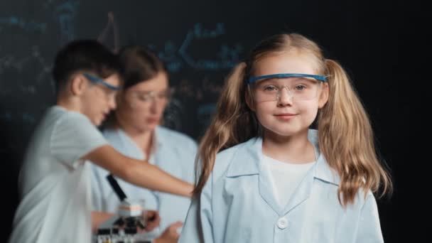 Mądra Biała Dziewczyna Pokazuje Kciuk Podczas Gdy Nauczyciel Uczeń Eksperymentują — Wideo stockowe
