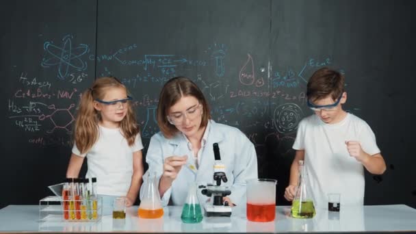 선생님이 조언을주는 액체를 혼합하는 솔루션으로 채워진 비커와 테이블에서 학생을 실험실 — 비디오
