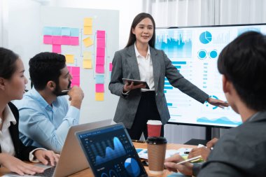 Çeşitli analist ekip arkadaşları el kaldırıyor, TV ekranında gösterge paneliyle sunum sırasında veri analizi pazarlaması hakkında sorular soruyorlar. Üretken ve profesyonel takım çalışması toplantısı. Uyum