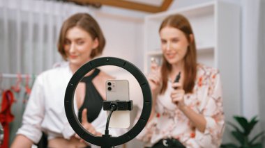 Etkilenen iki ortak canlı yayında video görüntülerini çekiyor makyaj malzemesi prim sosyal medya veya blog. Kozmetik stüdyosu ışıklandırmalı mutlu genç kız çevrimiçi pazarlama oturumu yayını için..