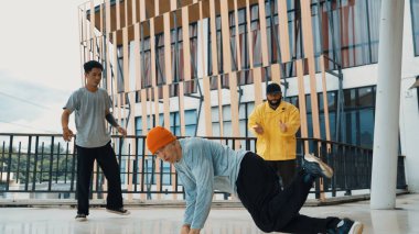 Hip hop takımı dans molası verirken, çok kültürlü bir arkadaş arkadaşını alkışlıyor ve alkışlıyor. Aktif ve enerjik sokak dansı. Açık hava sporu 2024. ÇalışmaComment.