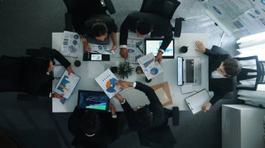 Çeşitli pazarlama ekipleri iş toplantısına hazırlanıyor. İş adamlarının yukarıdan aşağıya havadan görüşü masaya dizilmiş dizüstü bilgisayar ve tablet ile mali istatistikler. Yaratıcı iş. Müdürlük.