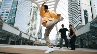 Bir grup profesyonel sokak dansçısı neşelen Asyalı hippi şehirde serbest dans ederken düşük açılı kamerayla çevrili insanlar tarafından. Break dans konsepti. Açık hava sporu 2024. Yumuşak bir şekilde..