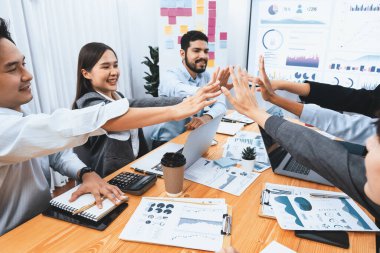 Çeşitli işletme ekipleri, kurumsal ofis toplantısında başarılı bir beşlik çakma ve mutluluk ifadeleri ile yapılan toplantıyı birlik başarısı ve profesyonel bütünlüğü temsil ederek kutluyorlar. Uyum