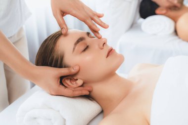 Kafkasyalı çift stres önleyici kafa masajının keyfini çıkarıyor ve lüks otellerde ya da otel spa salonlarında gündüz kaplıcalarında yüz güzelliği eğlencelerini şımartıyor. Sessiz.