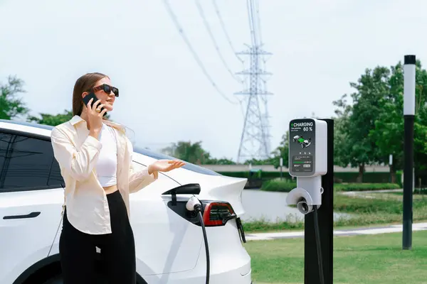 Young Woman Recharging Car Battery While Talk Phone Charging Station — Stock Photo, Image