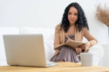 İnternette önemli bir iş için dizüstü bilgisayar kullanan Afro-Amerikalı bir kadın. Evde çalışan sekreter veya çevrimiçi içerik yazma.