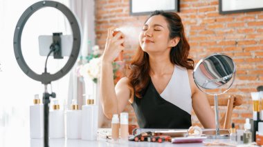 Kadın Etkilenen Vlog video görüntülerini canlı olarak çekiyor. Makyajın çoğu sosyal medya ya da blog 'u anlatıyor. Kozmetik stüdyosu ışıklandırmalı mutlu genç kız çevrimiçi pazarlama oturumu yayını için..