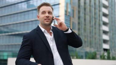 Zeki beyaz iş adamı, çatıda dururken iş arkadaşını mali strateji planlaması için arıyor. Proje yöneticisi pazarlama ekibiyle iletişim kurmak için cep telefonunu kullanıyor. Yaşam tarzı. Urbane.