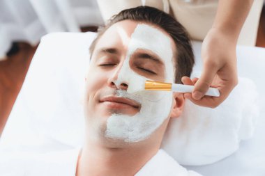 Kaplıca salonunun sakin atmosferi, insan müşterisi modern gün ışığında lüks yüz kremi masajıyla kendini yenileme zevkine kapılıyor. Yüz bakımı ve güzellik konsepti. Sessiz.