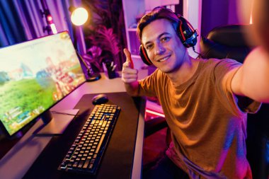 Akıllı oyun flamasının sunucu kanalı kameraya bakarken savaş takımının arka plandaki savaş gemisine silah çekmesini dijital neon siber odada kulaklık takmasını sağlıyor. Bireysel.