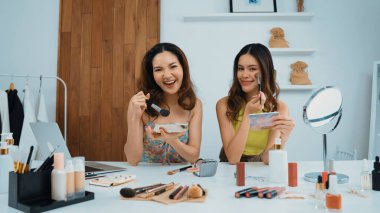 Etkilenen iki ortak canlı yayın yapan video görüntülerini sosyal medya ya da blog üzerinden gözden geçirir. Canlı kozmetik stüdyosu ışıklandırması olan mutlu genç bir kız pazarlama için internet üzerinden yayın yapıyor..