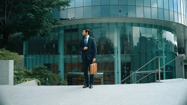 Skilled business man wearing formal suit while standing in urban city. Professional project manager standing in front of building while wearing formal suit. Office man finding for new job. Exultant.