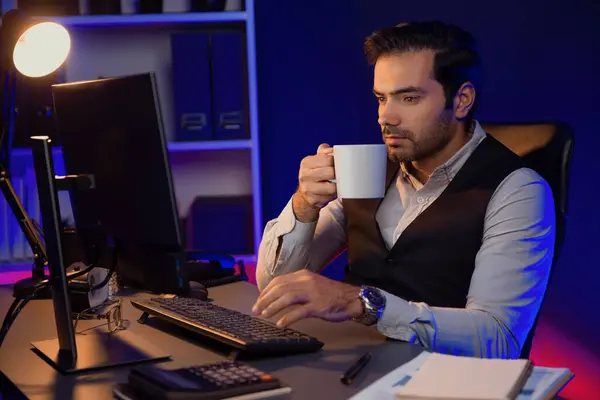 Smiling smart businessman remotely meeting sales team holding coffee cup, discussing research target market in product database on pc screen at purple neon dark light home office at night. Surmise.