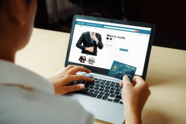 Genç adam, laptop bilgisayar başvurusu ya da web sitesinde online alışveriş yapmak için kredi kartı kullanıyor. E-ticaret ve online alışveriş konsepti. uds