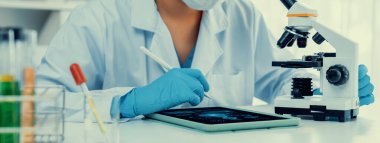 Laboratuvar araştırmacısı mikroskop kullanarak yeni ilaç ya da tedavi geliştirir. Laboratuvar mikrobiyoloji ekipmanları ile bilimsel uzmanlık ile sağlık hizmetlerinin teknolojik gelişimi. Panorama Katı