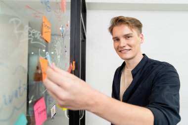 Kafkasyalı profesyonel iş adamının zihin haritası ve renkli yapışkan notlar kullanarak iş pazarlama fikrini kendine güvenle sunuşunun yakın görüntüsü. Proje konseptini başlat. Portre. Tertemiz..