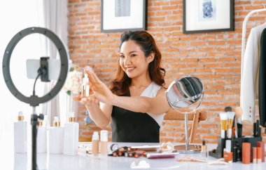 Kadın Etkilenen Vlog video görüntülerini canlı olarak çekiyor. Makyajın çoğu sosyal medya ya da blog 'u anlatıyor. Kozmetik stüdyosu ışıklandırmalı mutlu genç kız çevrimiçi pazarlama oturumu yayını için..