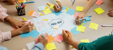 Yaratıcı bir girişim grubu beyin fırtınası fikri. Genç ve güzel iş adamları birlikte çalışıyor ve renkli yapışkan notlarla fikirleri paylaşıyorlar. Eline odaklan. Üst Manzara. Değiştirilmiş.