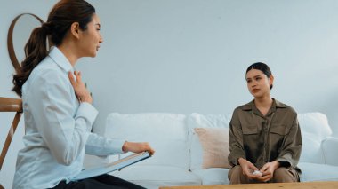 Psikologla ruh sağlığı terapisi gören üzgün travma sonrası stres bozukluğu olan bir kadın. Yaşam sonrası depresyon veya keder. Hayal kırıklığına uğramış genç bir kadın klinikteki duygular hakkında Vivancy psikoloğuyla konuşuyor.