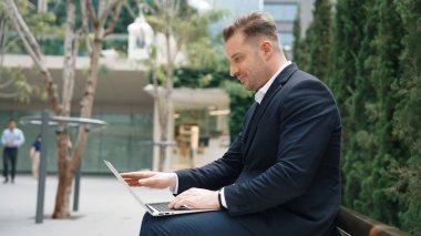 Green City 'de otururken bilgisayarla çalışan iş adamlarının yan görüntüsü. Akıllı yönetici bilgisayar yazma raporunu ve pazarlama stratejisini uzaktan kumandayla iş ekibiyle çalışırken kullanıyor. Urbane.