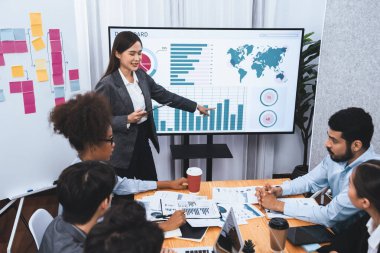 Genç Asyalı iş kadını modern toplantıda TV ekranında veri analizi paneli sunuyor. Bir grup iş adamıyla konferans odasında iş sunumu. Uyum